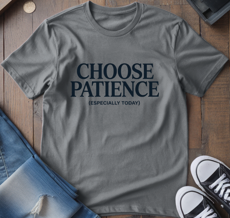 Gray t-shirt with 'CHOOSE PATIENCE (ESPECIALLY TODAY)' text on a wooden surface with jeans and sneakers.